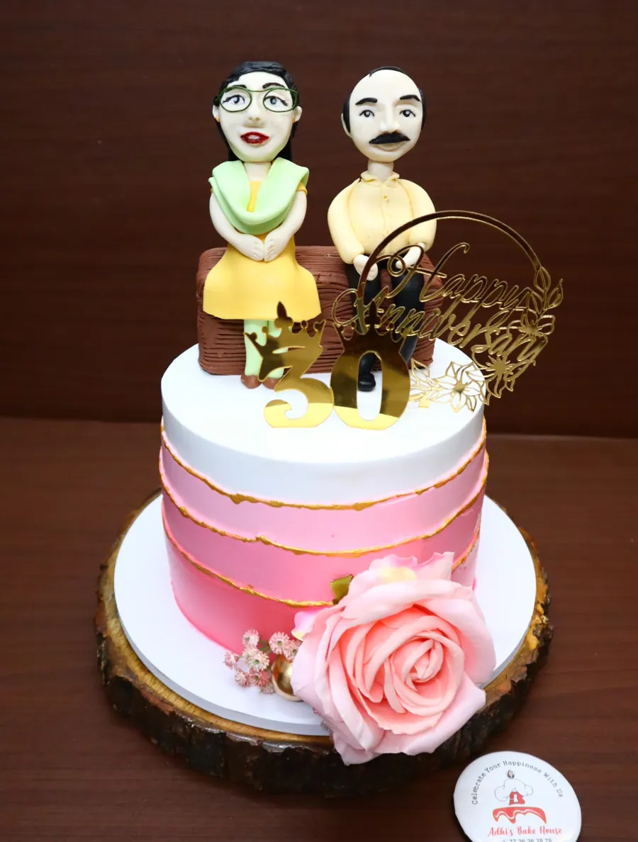 50th anniversary cake with a fondant couple and a pink rose