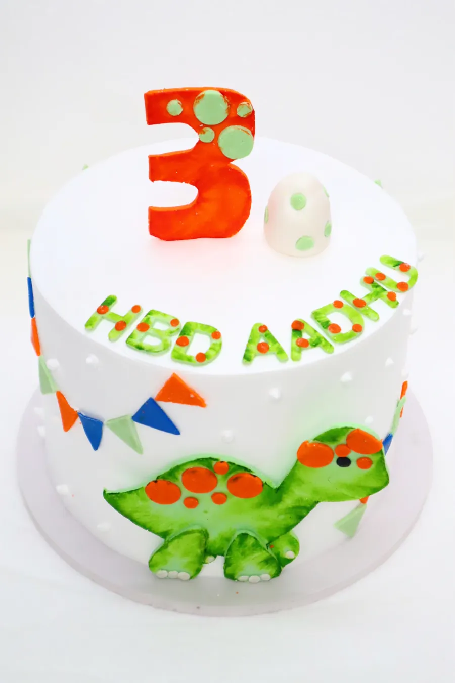 3rd birthday cake with a fondant dinosaur and bunting