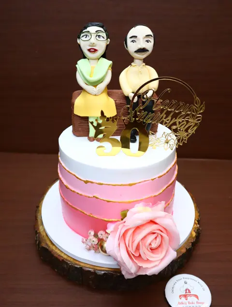 50th anniversary cake with a fondant couple and a pink rose