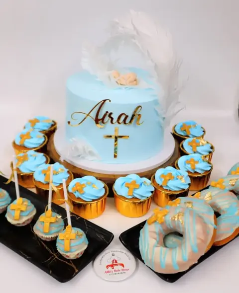 Blue baptism cake with gold cross, cupcakes, donuts and cake pops