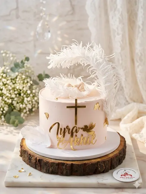 White christening cake with feathers and a gold cross