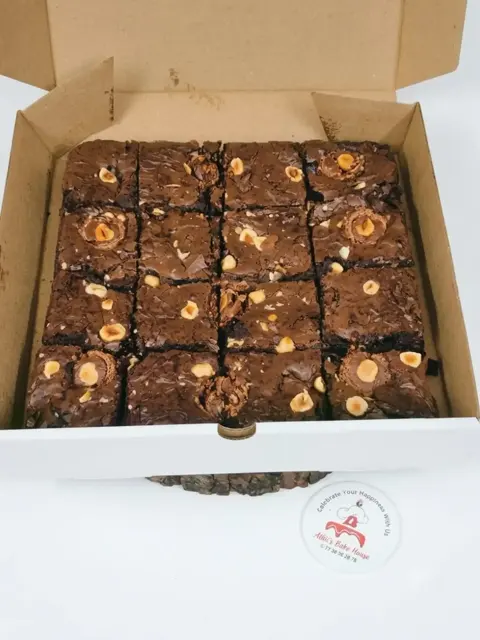 Box of fudgy brownies topped with hazelnuts